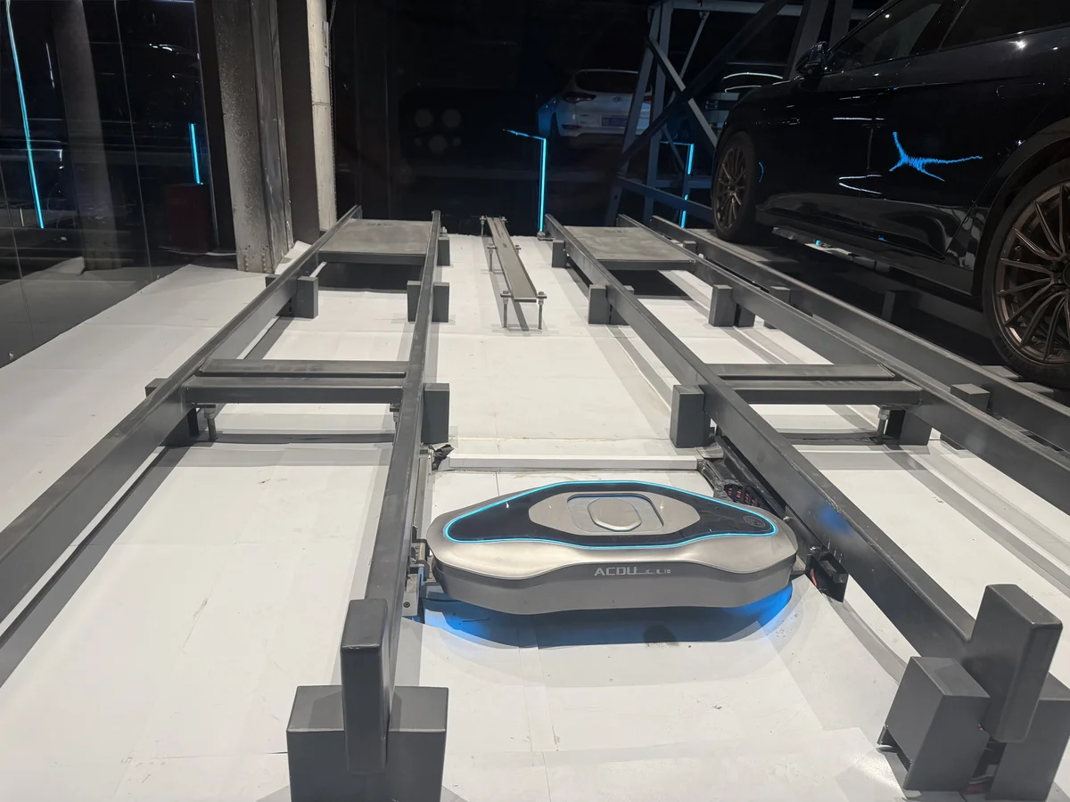 ACDU rail-mounted autonomous charging robot on floor tracks, serving multiple parking bays from a single unit