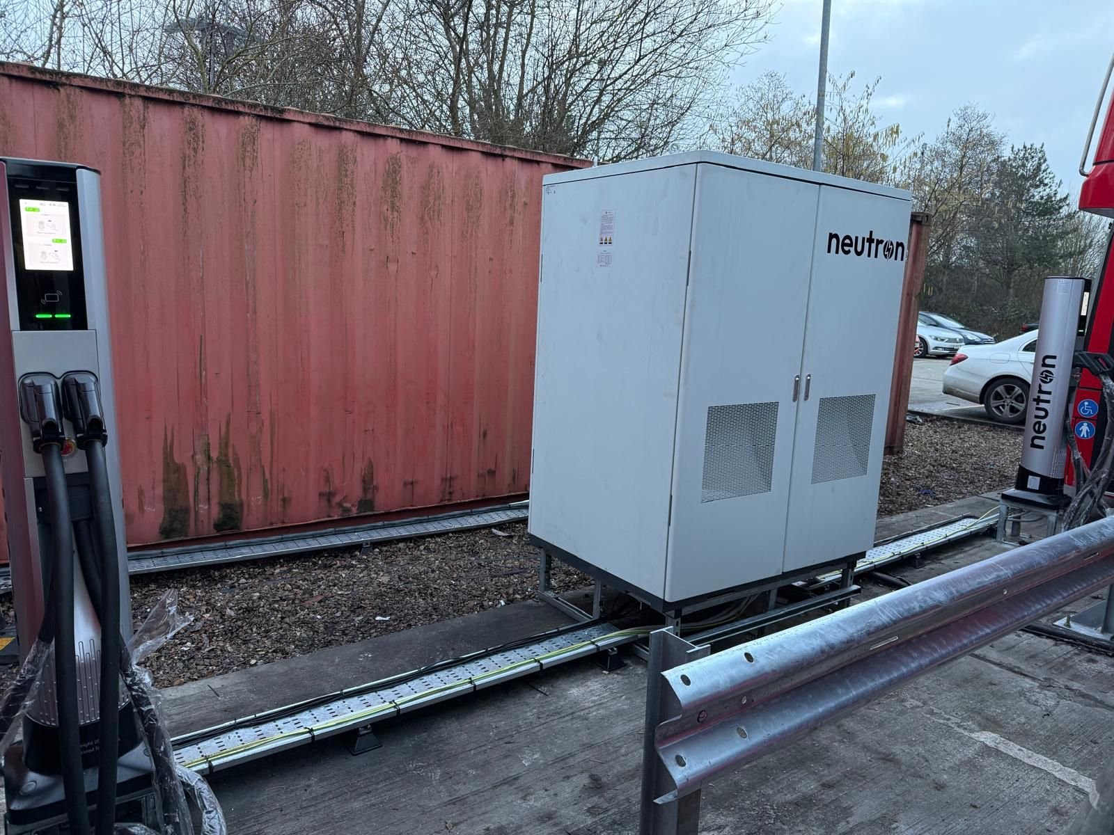 Neutron Systems Master Unit cabinet installed at a UK EV charging site with cable management tray and satellite terminals