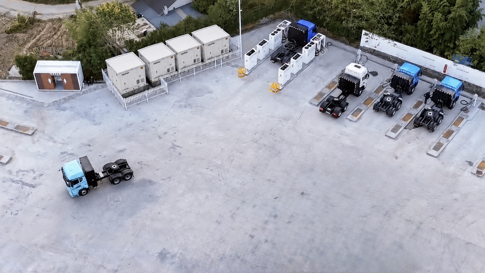 Aerial view of an electric HGV depot with modular charging cabinets and battery storage containers