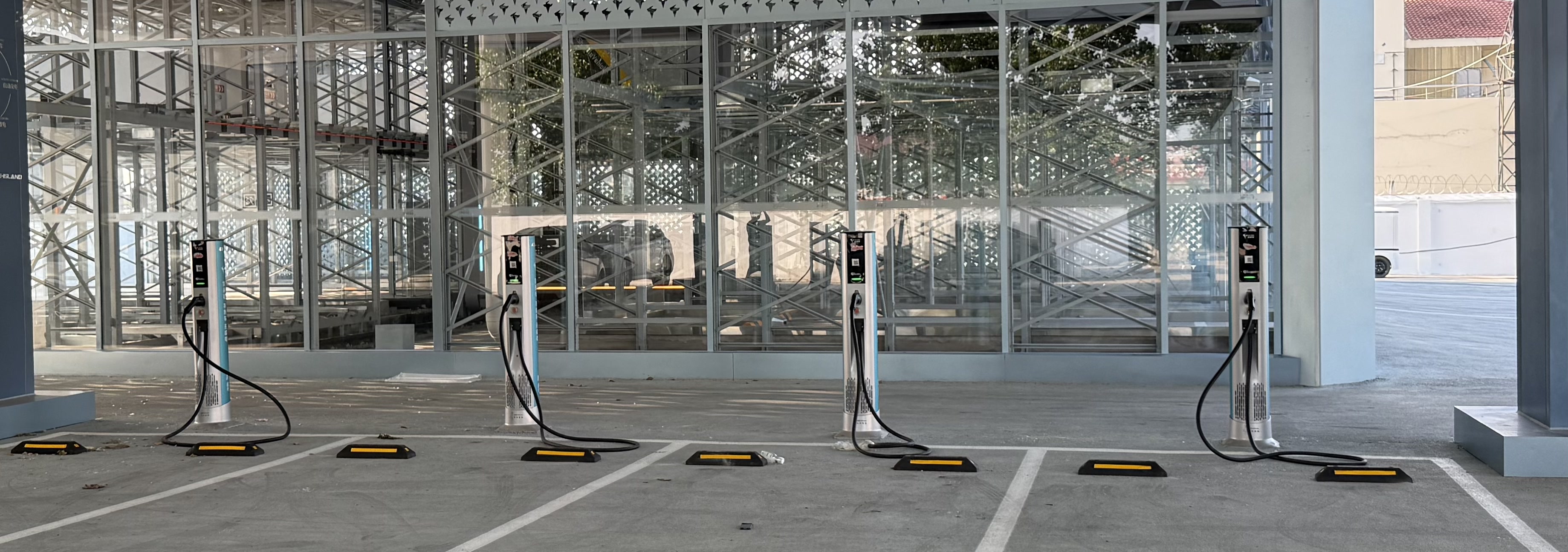 Row of Neutron DC Satellite Terminal chargers in a glass-facade commercial forecourt