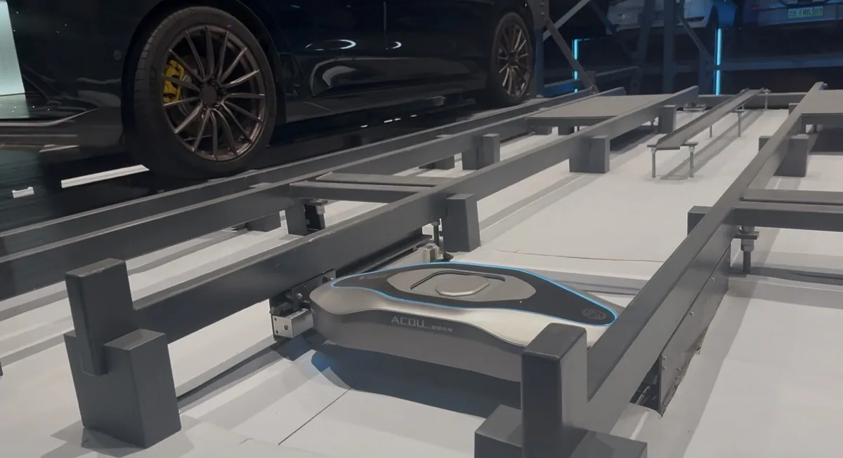 Automatic Charging Dock unit positioned on a rail beneath a stacked vehicle's wheel arch